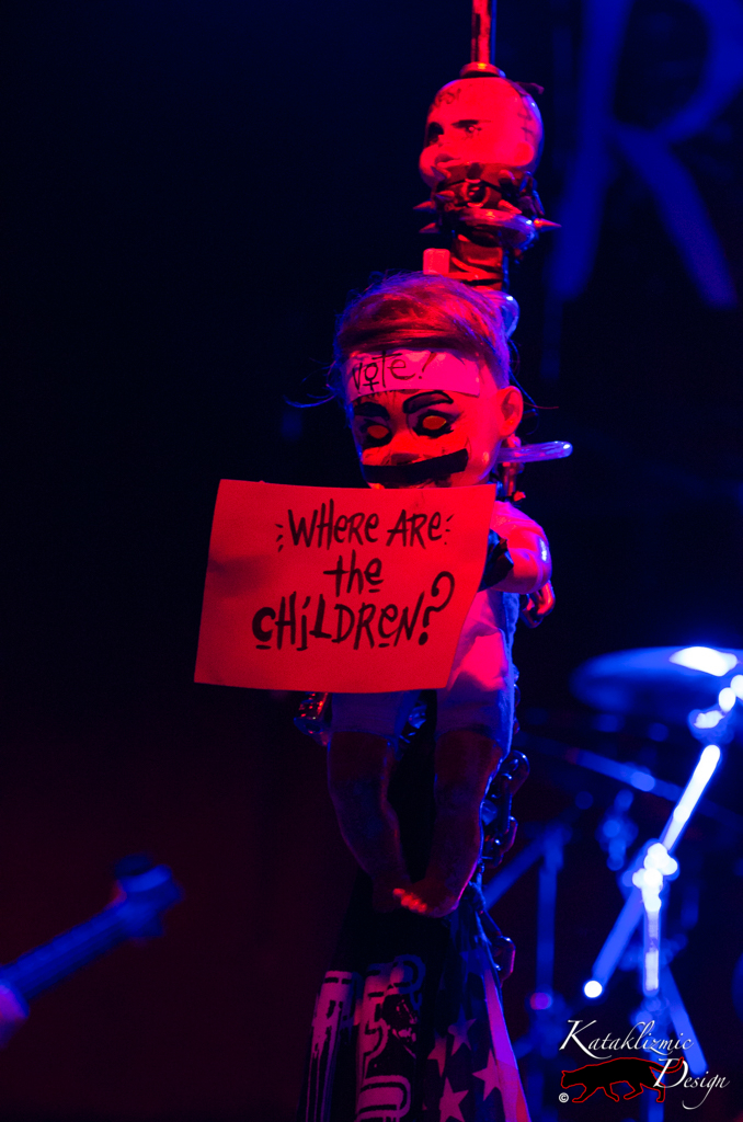 Creepy baby doll holding a sign reading "Where are the children?" - Photography: Katherine Amy Vega